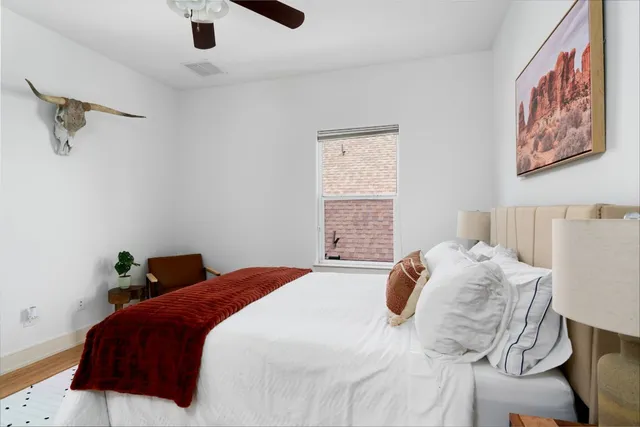 a bedroom with a bed and a painting on the wall