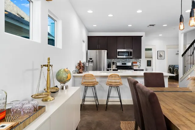 a kitchen with stainless steel appliances kitchen island granite countertop a stove a sink a dining table and chairs