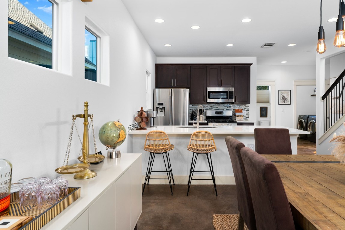 3012 Neal Street Austin, TX 78702 - Photo 10 of 39 a kitchen with stainless steel appliances kitchen island granite countertop a stove a sink a dining table and chairs