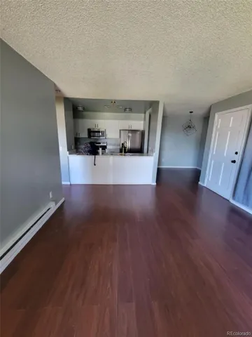 a view of a living room hardwood floor and a kitchen
