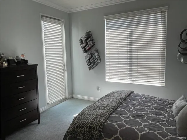 a bed sitting in a bedroom next to a window