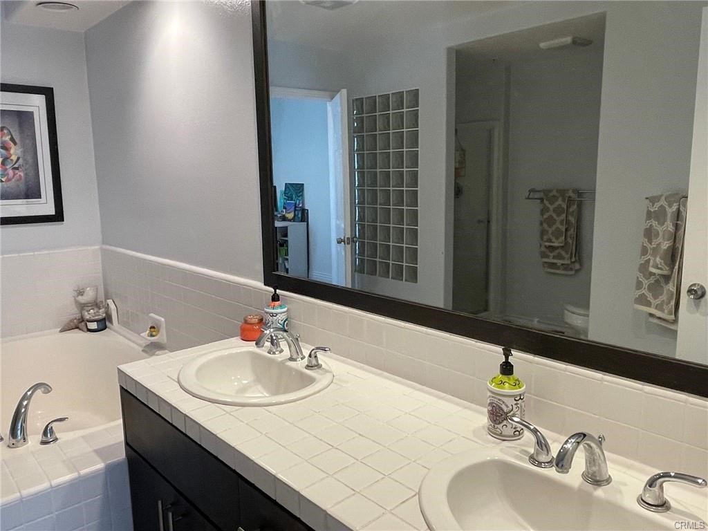 2233 Martin, Unit 413 Irvine, CA 92612 - Photo 33 of 38 a bathroom with a granite countertop sink and a mirror
