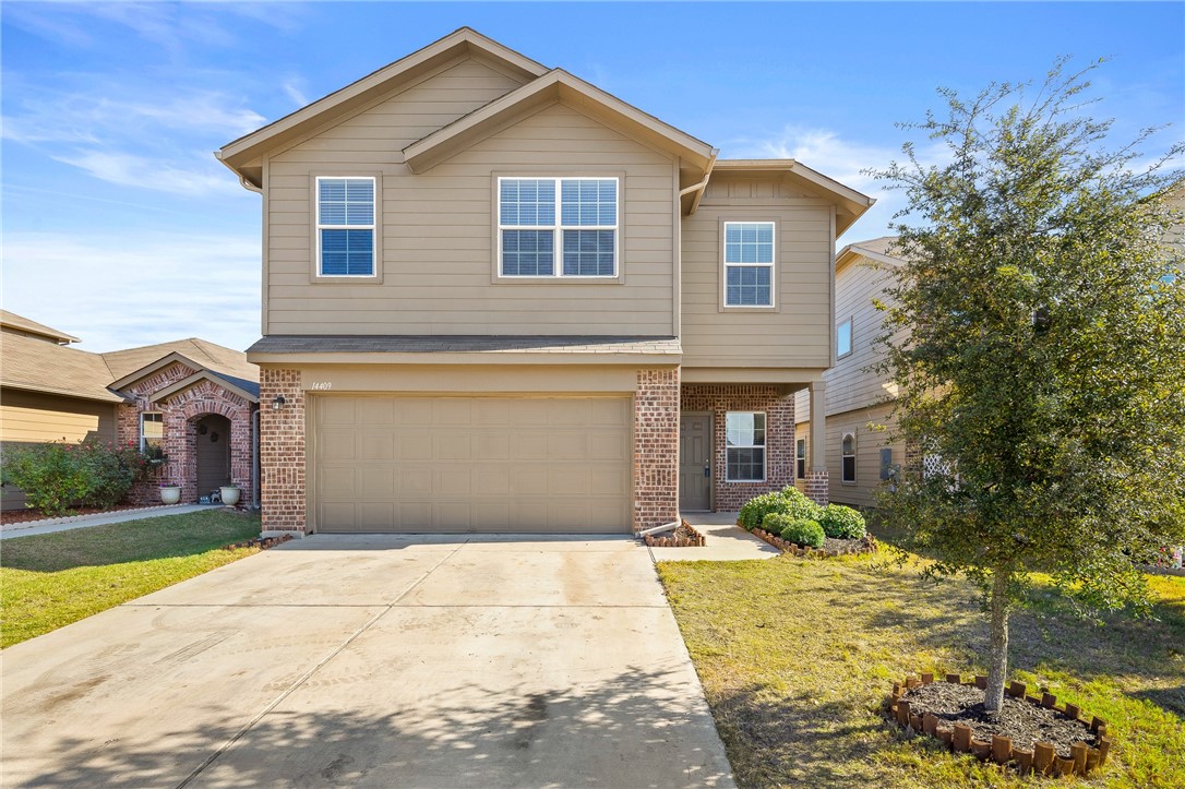 a front view of a house with a yard and garage