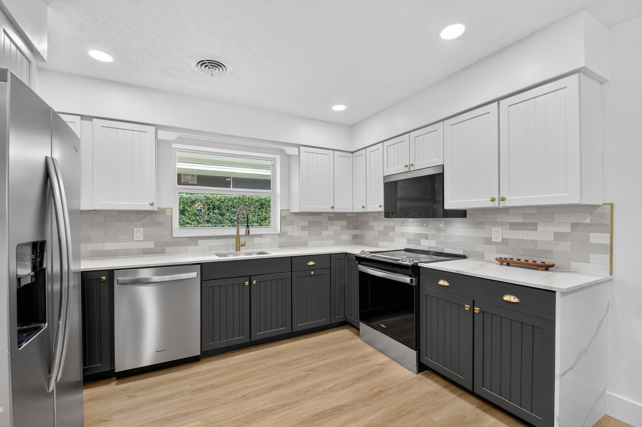 1221 Singer Drive Singer Island, FL 33404 - Photo 4 of 29 a kitchen with stainless steel appliances granite countertop a sink and stove top oven