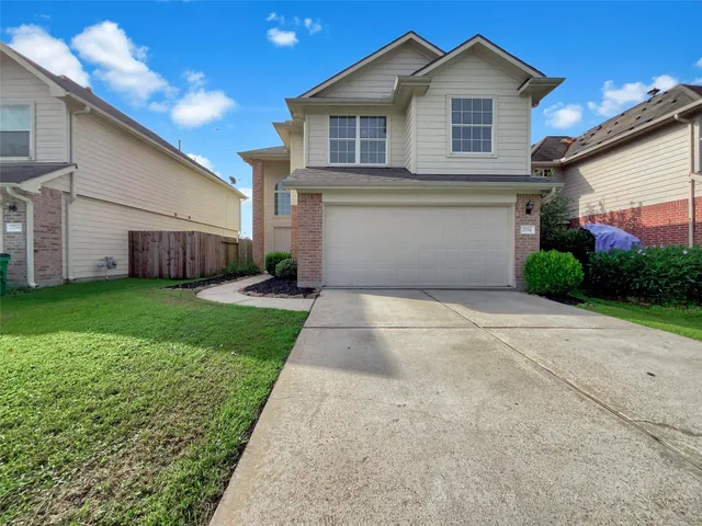 a view of a house with a yard and garage