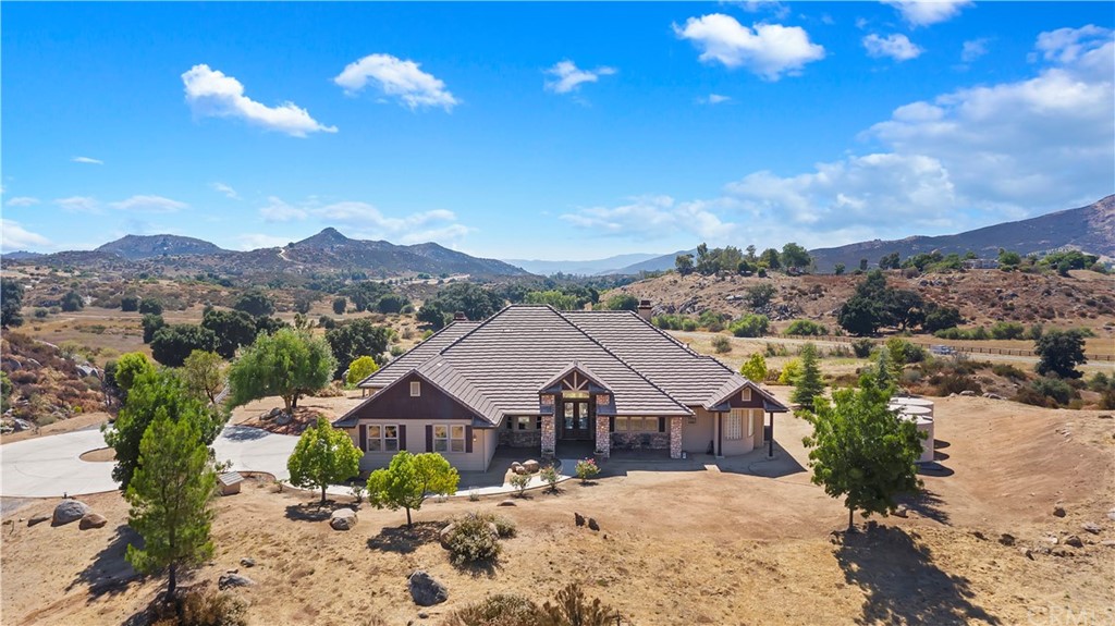 a view of a house with a big yard plants and large trees
