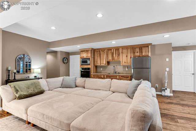 182 Raptor Court Canon City, CO 81212 - Photo 28 of 50 Back in the family room the generously sized room easily accommodates a large sectional along with additional seating and activity areas, offering flexibility for entertaining, relaxing, or hobbies.