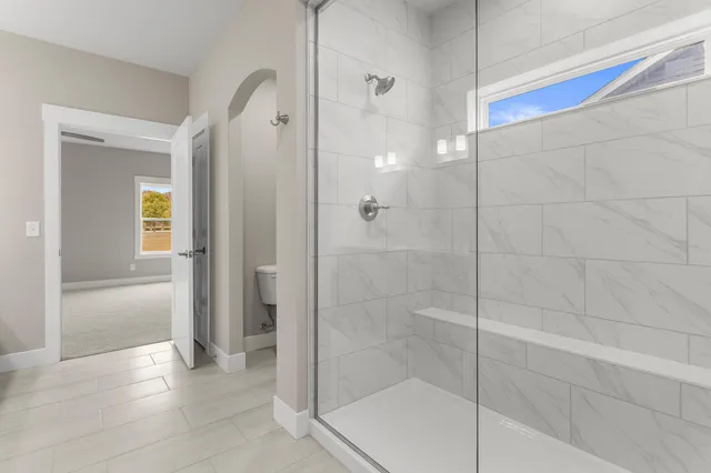 a bathroom with a shower and a glass door