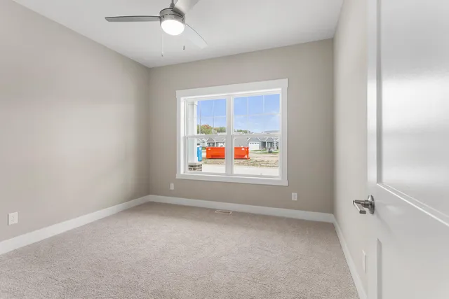 an empty room with window ceiling fan and windows