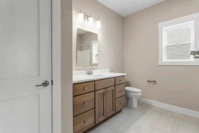 a bathroom with a toilet sink and mirror