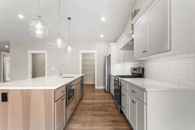 a kitchen with stainless steel appliances a sink stove and cabinets