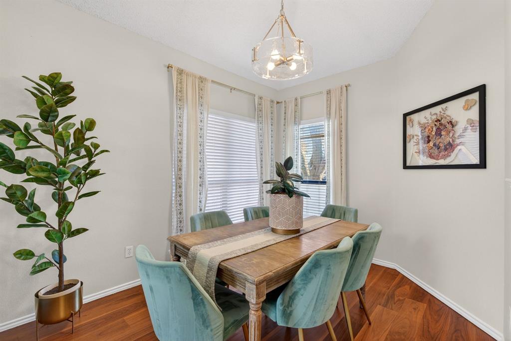 2941 Hunters Point Lane Carrollton, TX 75007 - Photo 11 of 40 a dining room with furniture potted plants and wooden floor