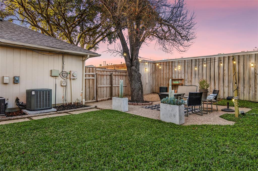 2941 Hunters Point Lane Carrollton, TX 75007 - Photo 36 of 40 a view of a backyard with table and chairs and a large tree