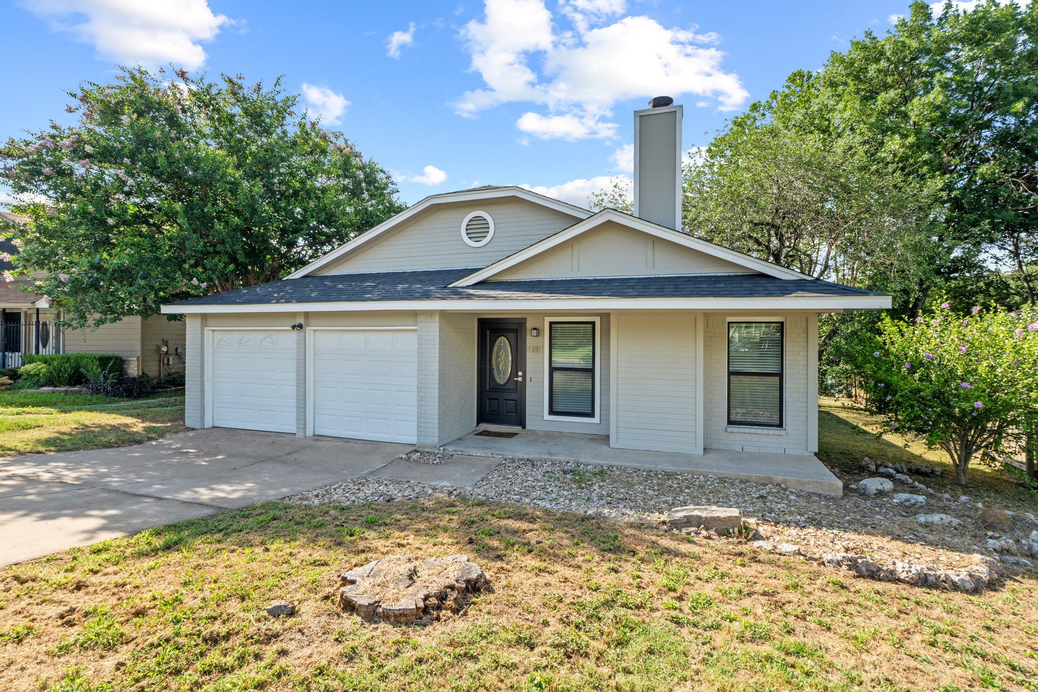 11811 Rotherham Drive Austin, TX 78754 - Photo 2 of 37 A welcoming facade with a dual garage, surrounded by verdant landscaping.