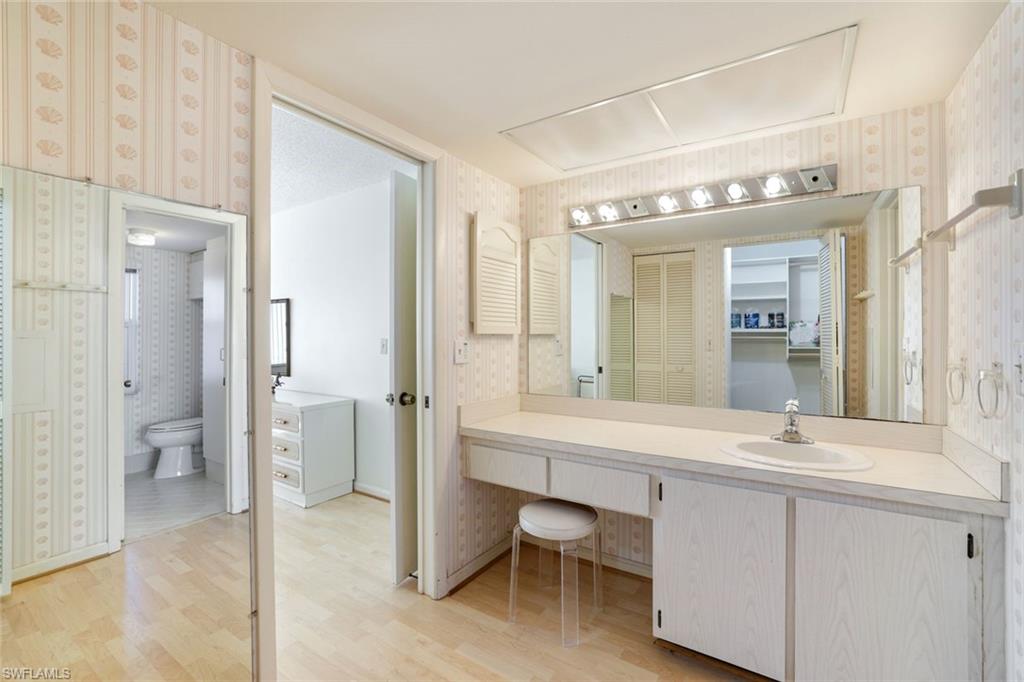 247 Winners Circle, Unit 5 Naples, FL 34112 - Photo 12 of 24 Bathroom with wallpapered walls, vanity, light wood finished floors, and a walk in closet