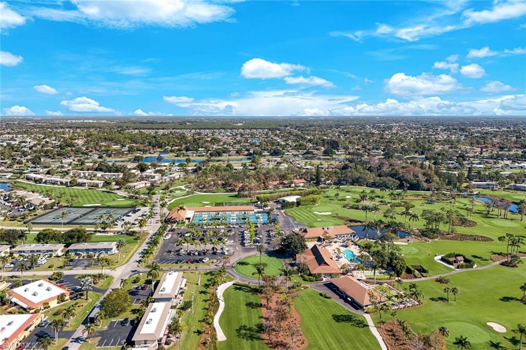 247 Winners Circle, Unit 5 Naples, FL 34112 - Photo 2 of 24 Aerial view of a local golf course and a large body of water
