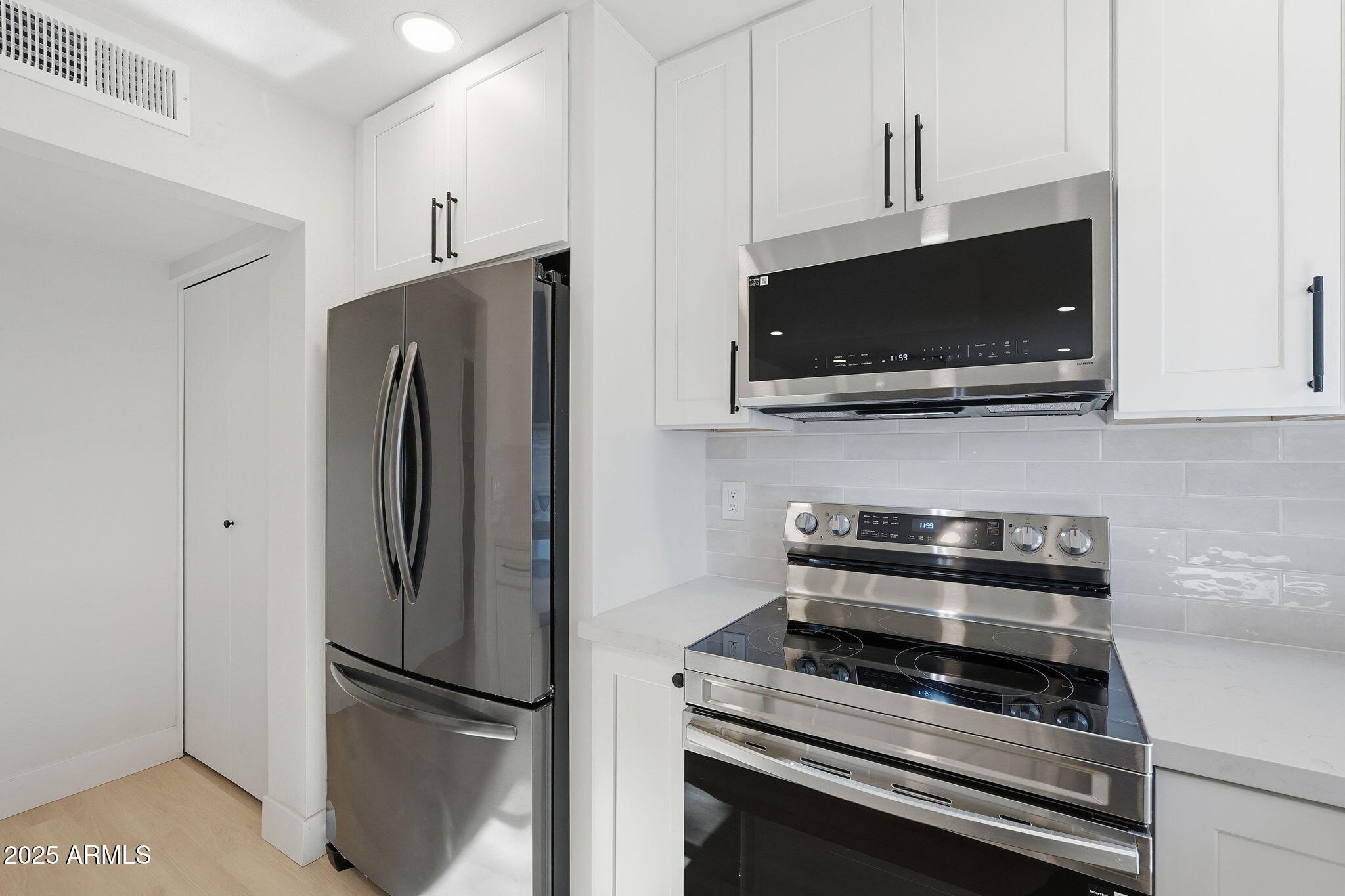 5839 West Hearn Road Glendale, AZ 85306 - Photo 12 of 35 a kitchen with stainless steel appliances a refrigerator stove and microwave