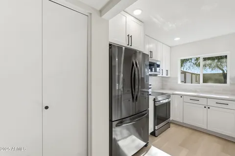 a kitchen with stainless steel appliances granite countertop a refrigerator and a sink