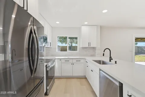 a kitchen with stainless steel appliances granite countertop a sink stove and refrigerator