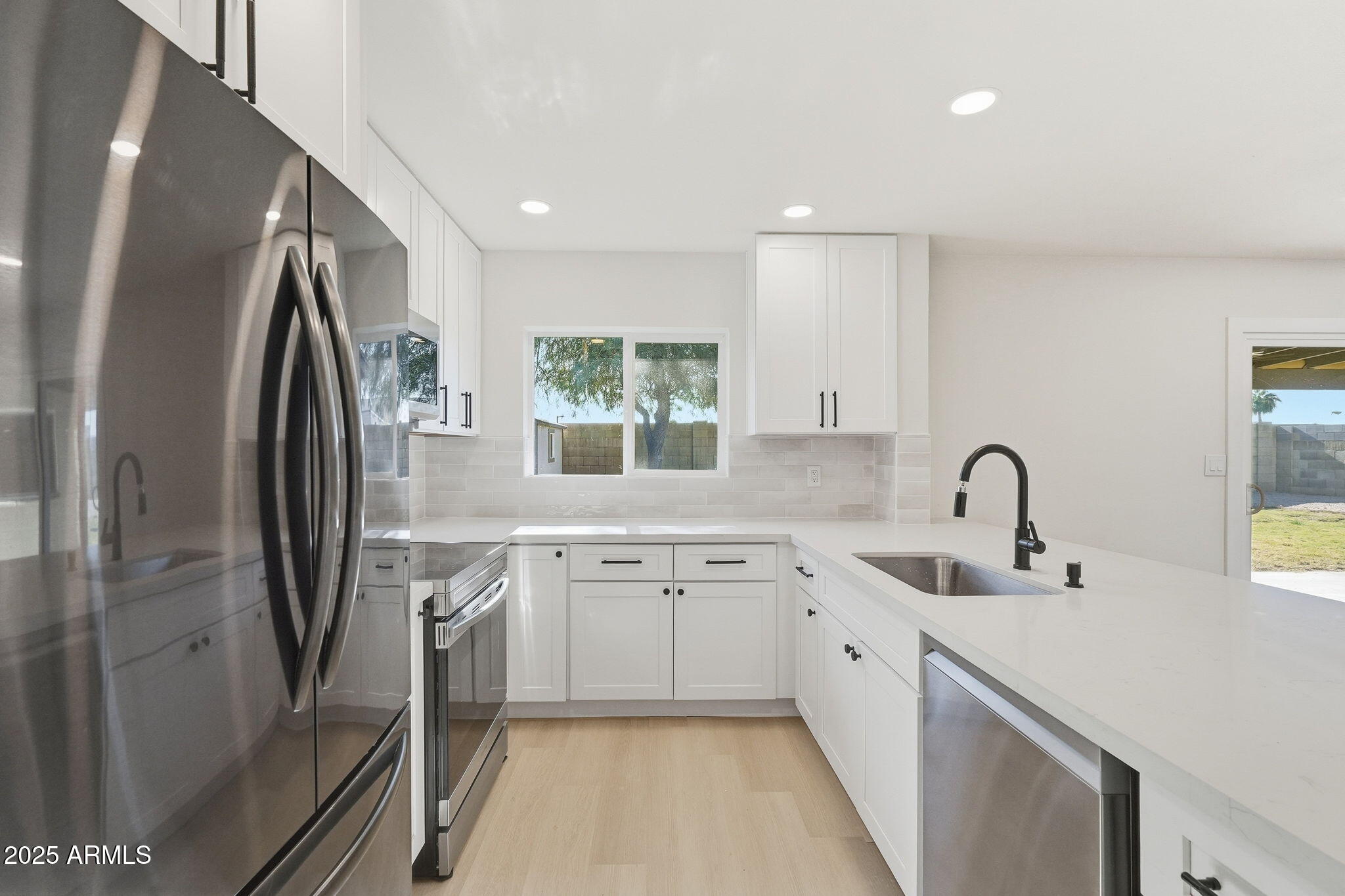 5839 West Hearn Road Glendale, AZ 85306 - Photo 14 of 35 a kitchen with stainless steel appliances granite countertop a sink stove and refrigerator