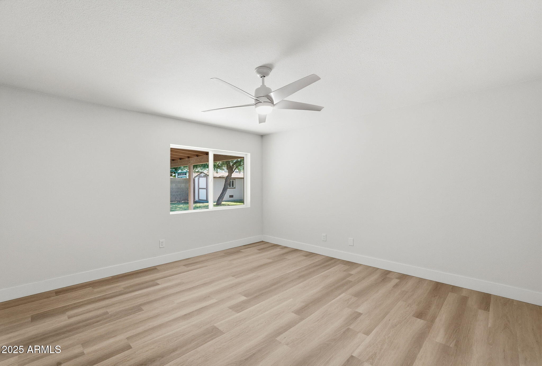 5839 West Hearn Road Glendale, AZ 85306 - Photo 15 of 35 an empty room with a window and a ceiling fan