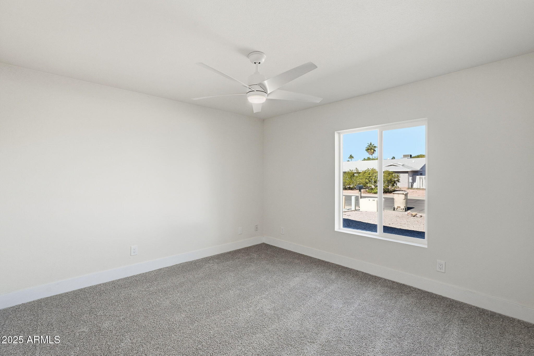 5839 West Hearn Road Glendale, AZ 85306 - Photo 21 of 35 an empty room with a window and a ceiling fan