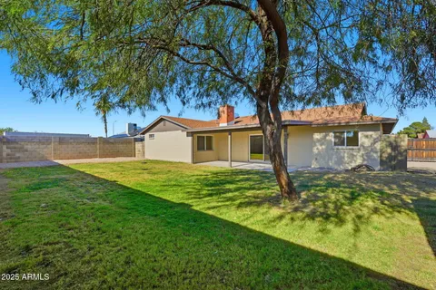 a front view of house with yard and trees in the background