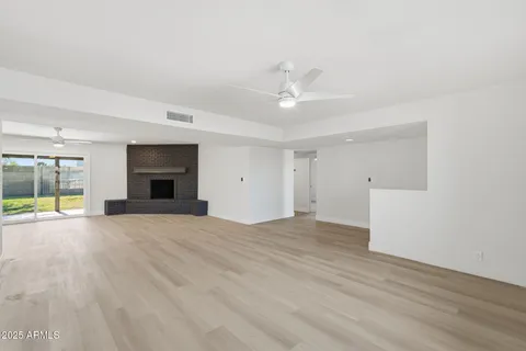 a view of empty room with wooden floor and fireplace