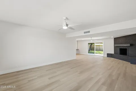 an empty room with windows and fireplace