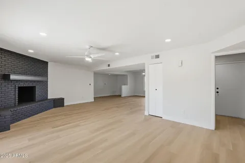 a view of an empty room with a fireplace and a window