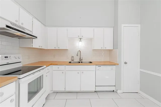 a kitchen with white cabinets appliances and sink