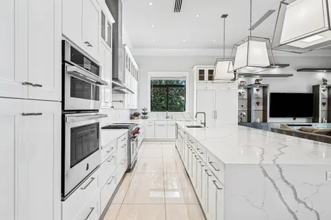 a kitchen with a large window and cabinets