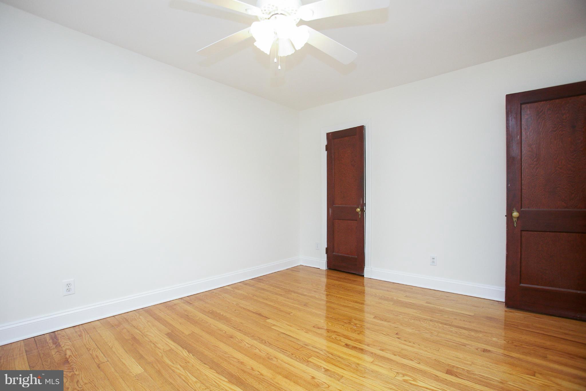 309 Overbrook Road Baltimore, MD 21212 - Photo 14 of 26 an empty room with wooden floor and fan