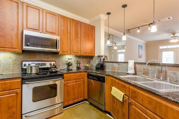a kitchen with stainless steel appliances granite countertop a sink a stove and cabinets