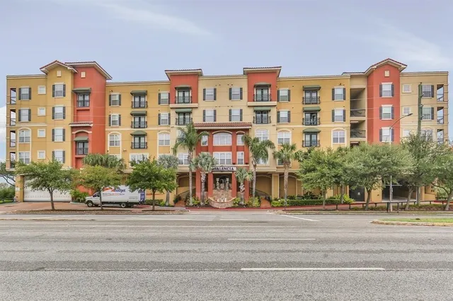 a front view of a building with swimming pool and chairs