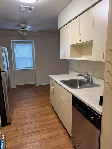 a kitchen with a sink cabinets and wooden floor