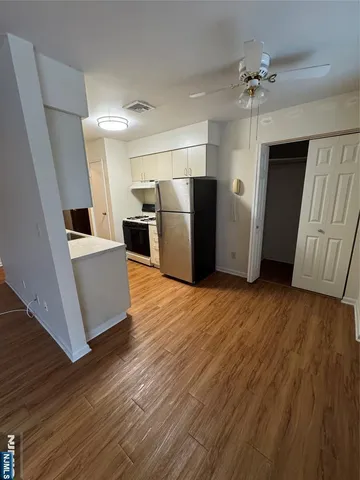 a view of a kitchen with furniture and wooden floor