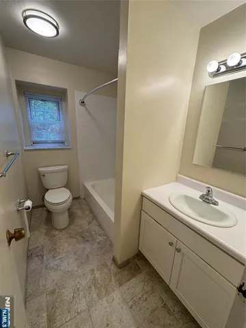 a bathroom with a granite countertop sink a toilet and a mirror