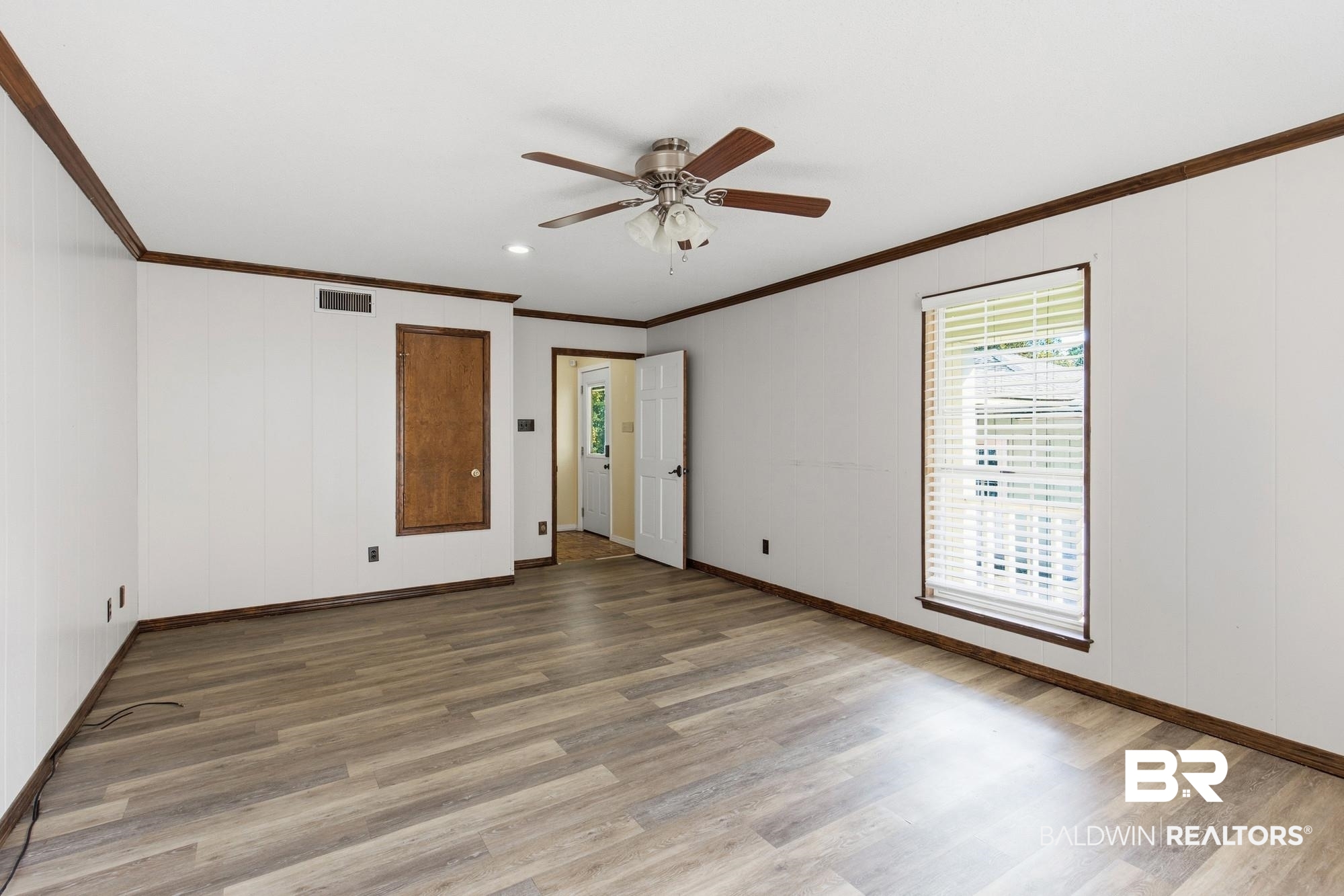 9215 Shiloh Drive Mobile, AL 36695 - Photo 15 of 32 Unfurnished room featuring crown molding, light wood-type flooring, and a ceiling fan