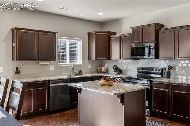 a kitchen with stainless steel appliances granite countertop a sink stove and microwave