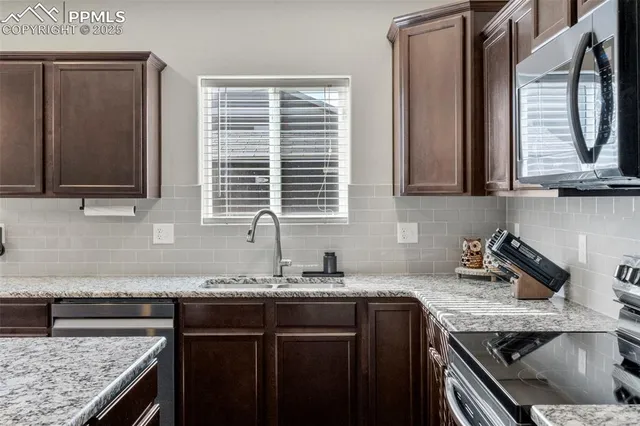 a kitchen with granite countertop a sink and a stove