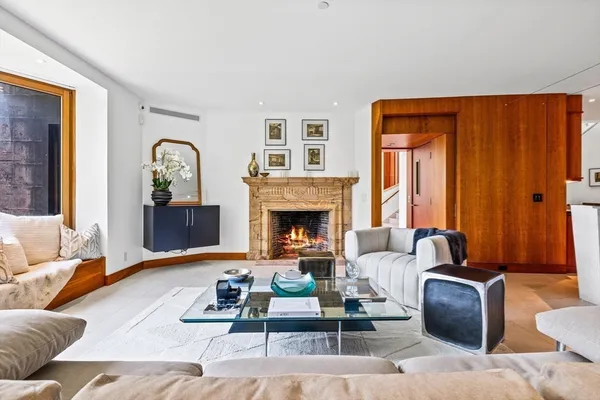 a living room with furniture fireplace and a large window