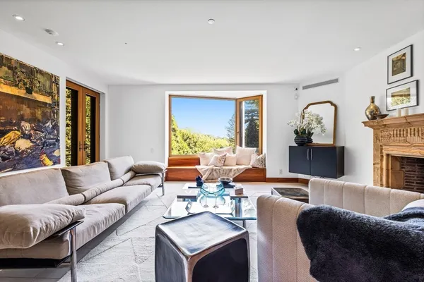 a living room with fireplace furniture and a large window