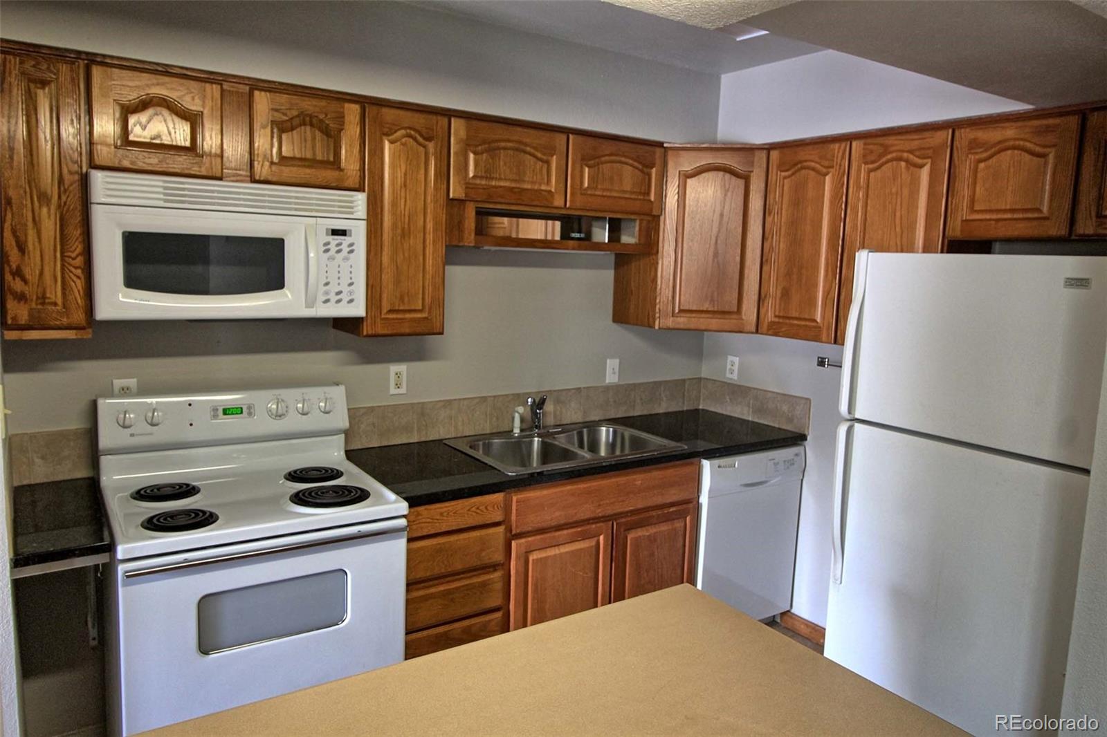 a kitchen with stainless steel appliances granite countertop a refrigerator stove and sink