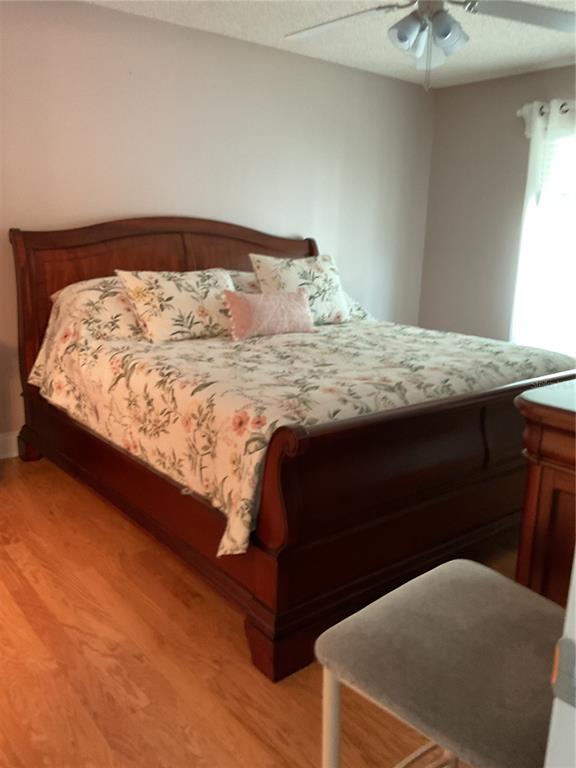 2655 Pine Ridge Way North, Unit D3 Palm Harbor, FL 34684 - Photo 23 of 31 a bedroom with a bed and a chandelier