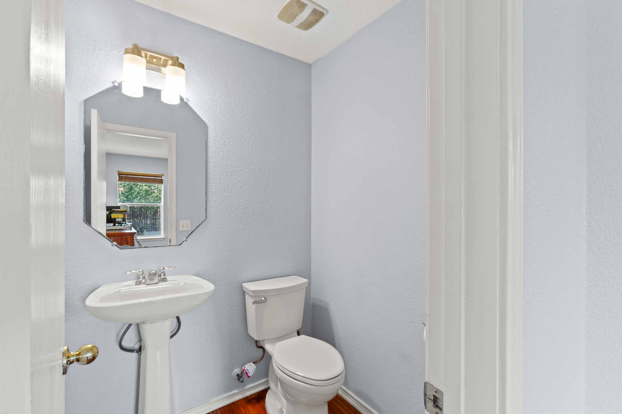 270 Endeavour Kyle, TX 78640 - Photo 10 of 20 Bathroom featuring a pedestal sink, white toilet, and a framed mirror with a light fixture