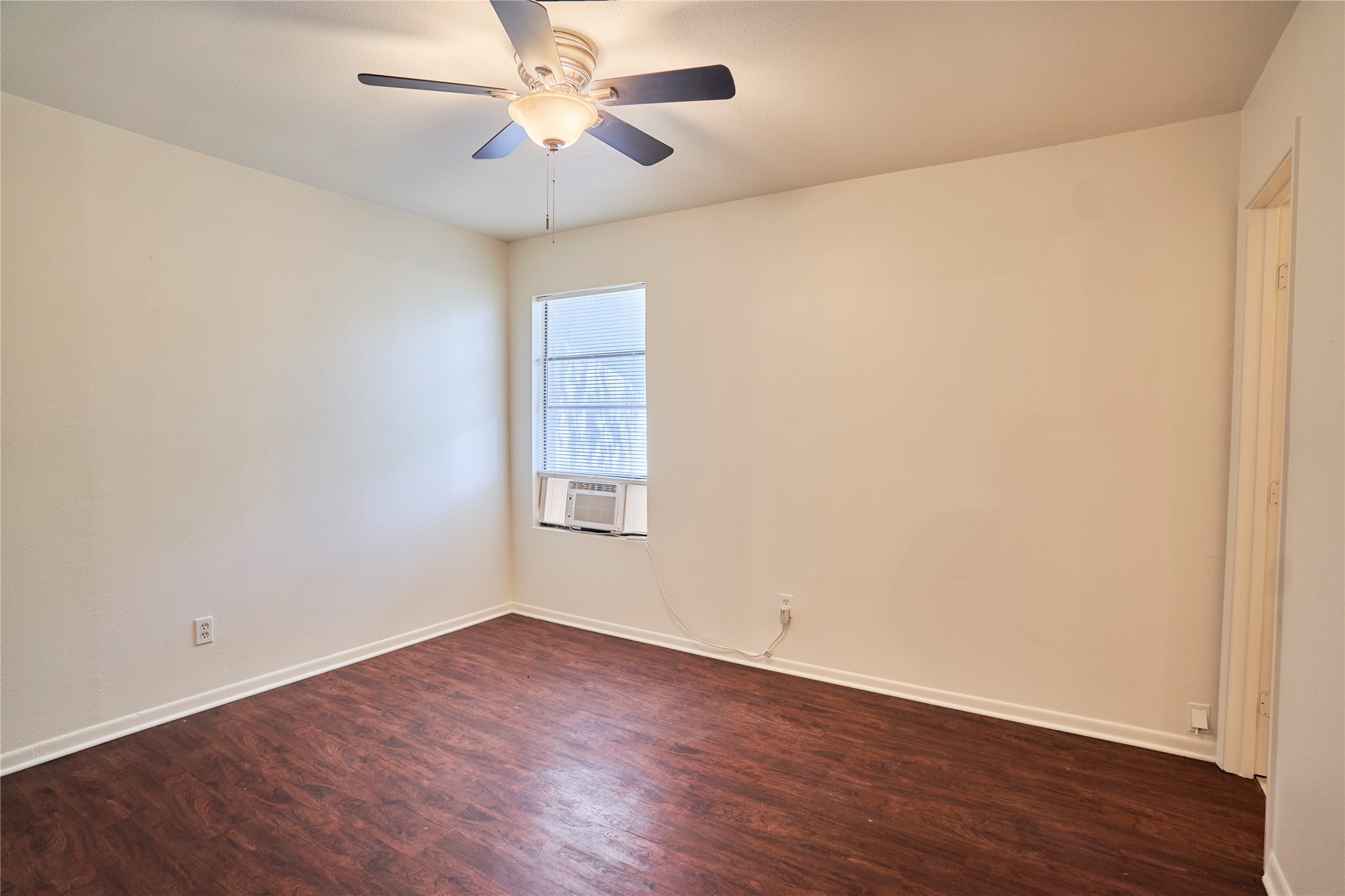 23393 Nameless Road, Unit 171 Leander, TX 78641 - Photo 7 of 15 A well-lit room featuring rich wood flooring and a refreshing ceiling fan.