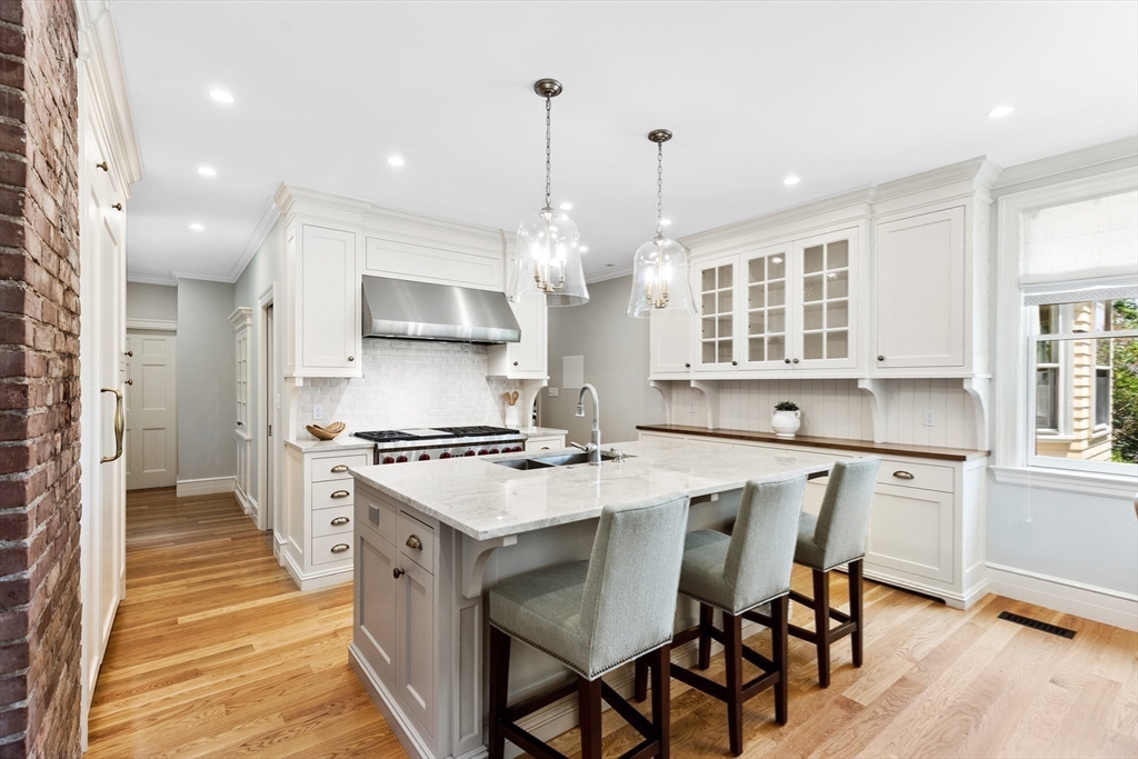 10 Eliot Road Lexington, MA 02421 - Photo 15 of 40 a kitchen with a dining table chairs stove and white cabinets