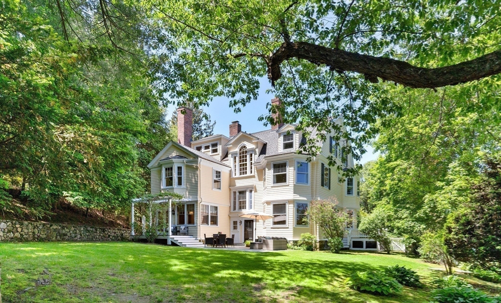 10 Eliot Road Lexington, MA 02421 - Photo 4 of 40 a front view of a house with a yard table and chairs