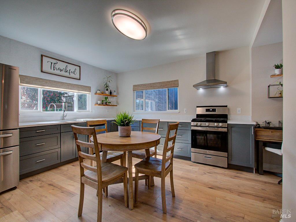 1002 Cedar Street Fort Bragg, CA 95437 - Photo 10 of 26 a kitchen with a table chairs and stainless steel appliances